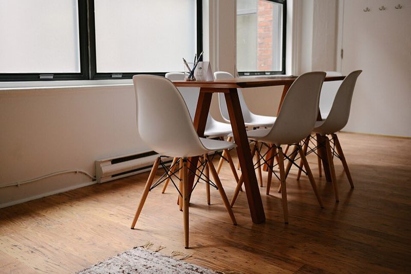 A meeting table and chairs beside a window