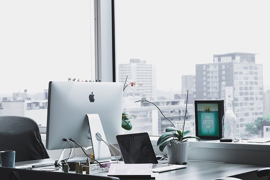 A desk beside a window overlooking the city