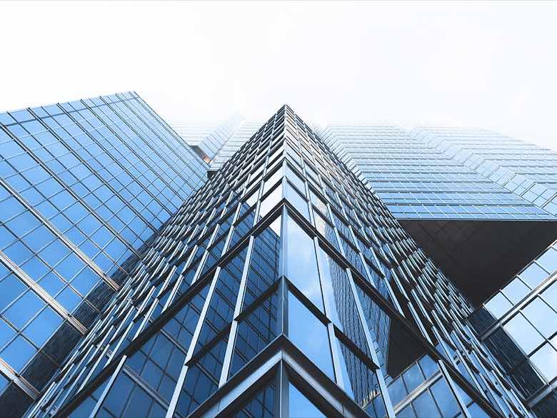 A glass office tower seen from below